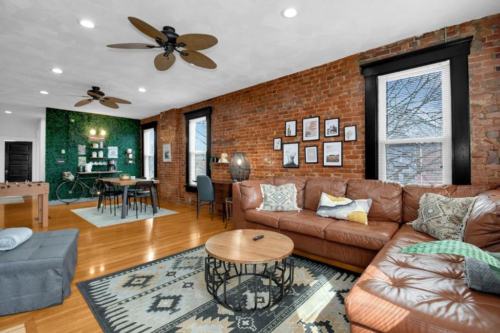a living room with a couch and a brick wall at Urban Loft 2-story 1BR Near DT on Historic Street in Columbus