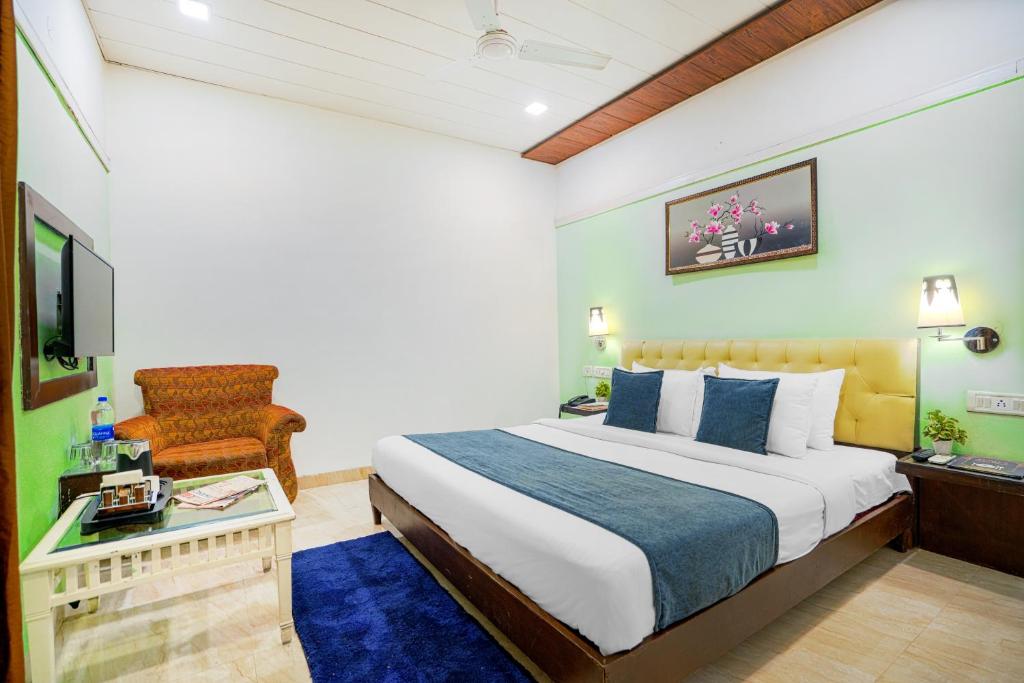 um quarto com uma cama, uma cadeira e uma televisão em Hotel Seven em Chandīgarh