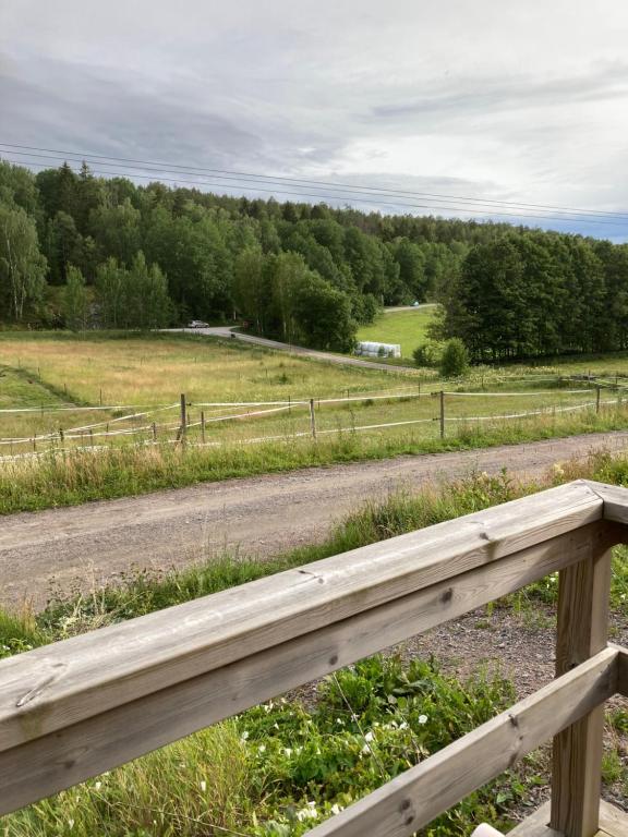 uma cerca de madeira ao lado de uma estrada de terra batida em Asplunda Gård, Kolmården, stuga 5 em Kolmården