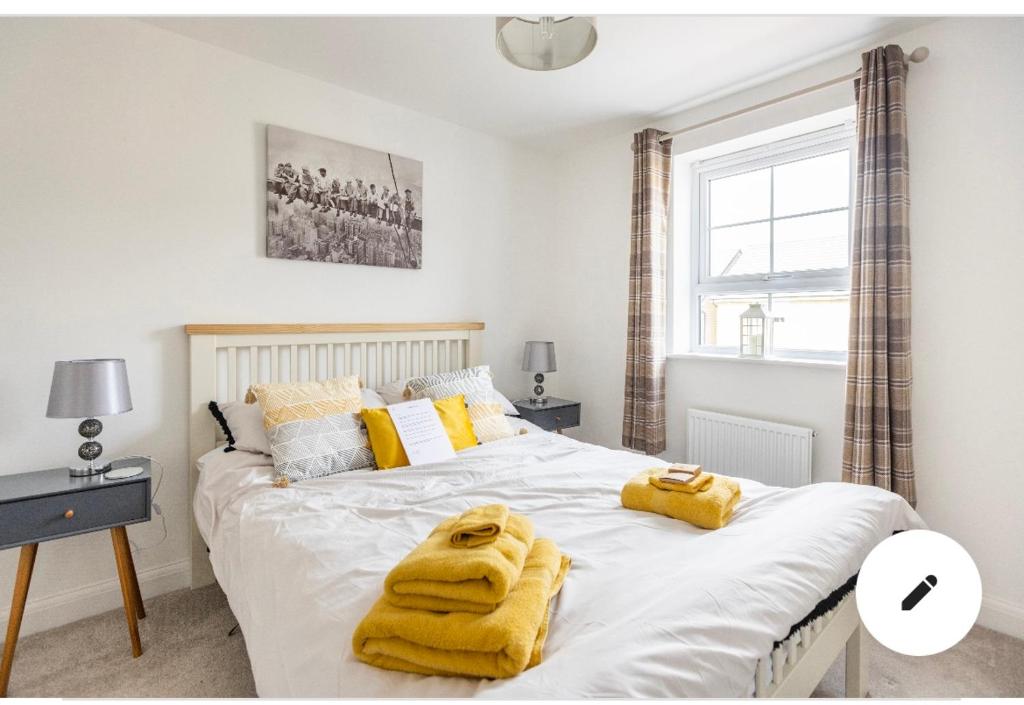 a bedroom with a large bed with yellow towels on it at Cobbeydale room in Silsden