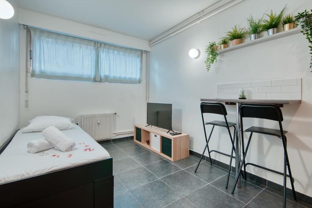 a room with a bed and two chairs and a counter at MILANO - Studio à deux pas de l’Avenue du Prado in Marseille