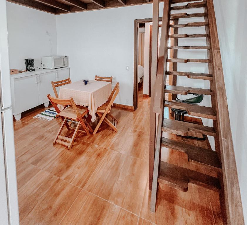 a kitchen and dining room with a table and a staircase at Apartamentos Dumont in Monte Verde