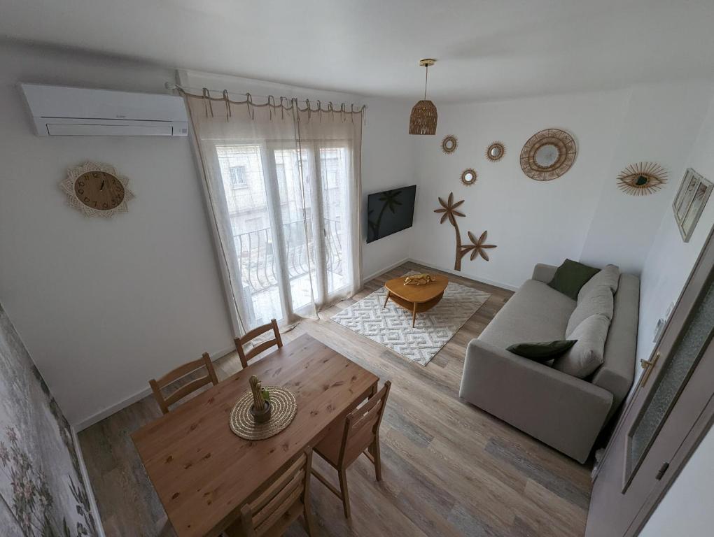 een woonkamer met een bank en een tafel bij L'exotic' 1 à 4 voyageurs in Perpignan