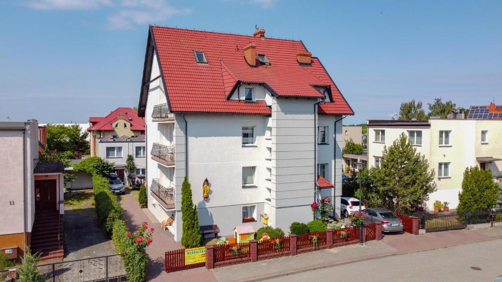 une grande maison blanche avec un toit rouge dans l'établissement Szyper, à Jastarnia