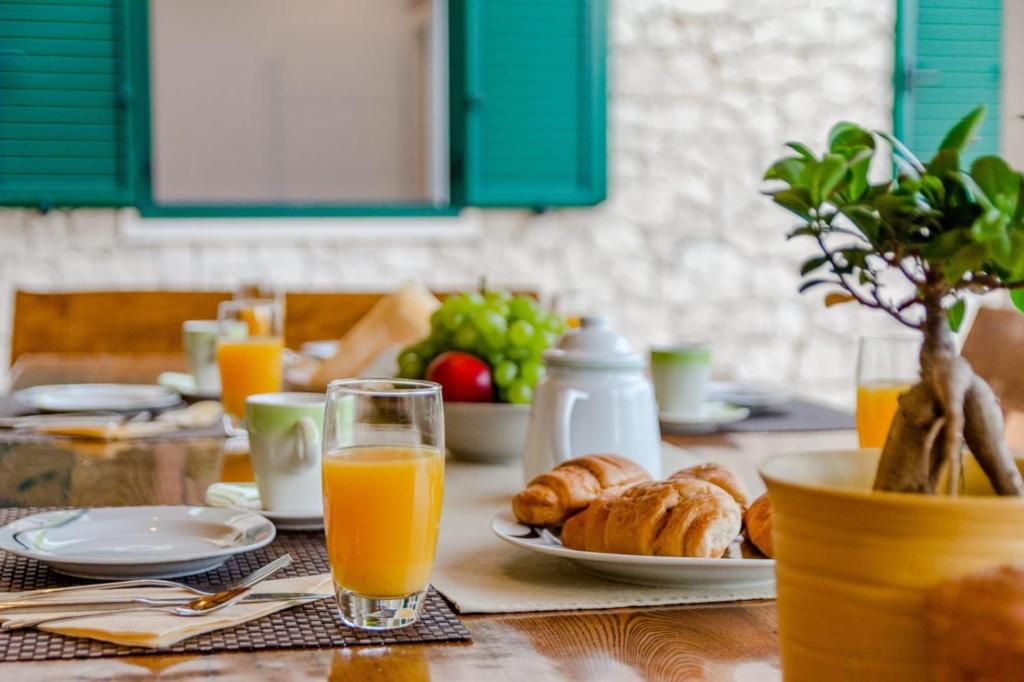 uma mesa com um prato de pão e sumo de laranja em Apartman Mauro em Bol