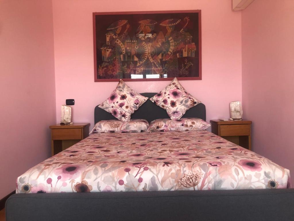a bedroom with a large bed with pink walls at La Dolce Dimora degli Angeli in Rome