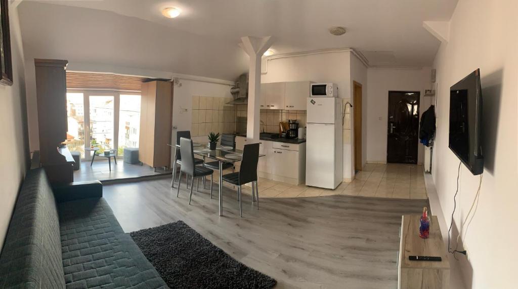 cocina y sala de estar con mesa y sillas en Apartament în regim hotelier en Timisoara