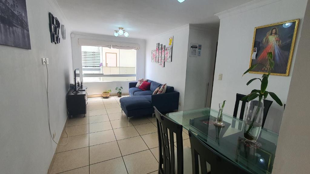 a living room with a blue couch and a table at Apartamento BREÑA in Lima