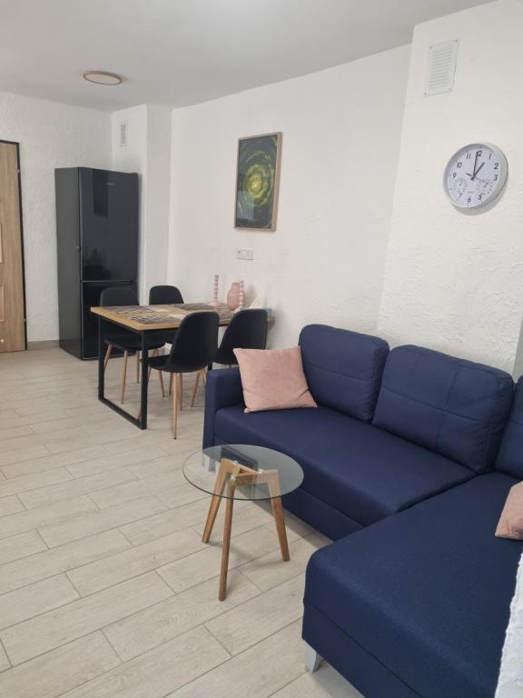 a living room with a blue couch and a table at Apartament Nova Kamienica 3 in Łagów