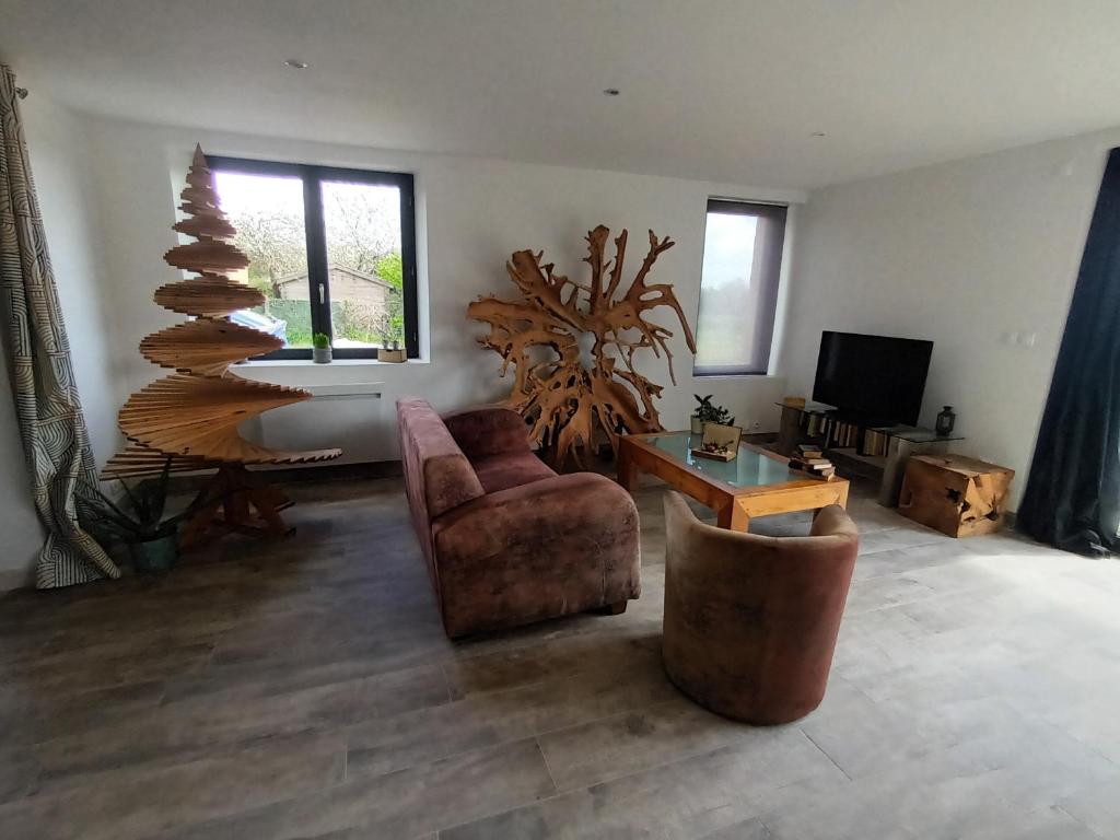 ein Wohnzimmer mit einem Stuhl und einem Weihnachtsbaum in der Unterkunft Un Brain de nature in La Chapelle-de-Brain