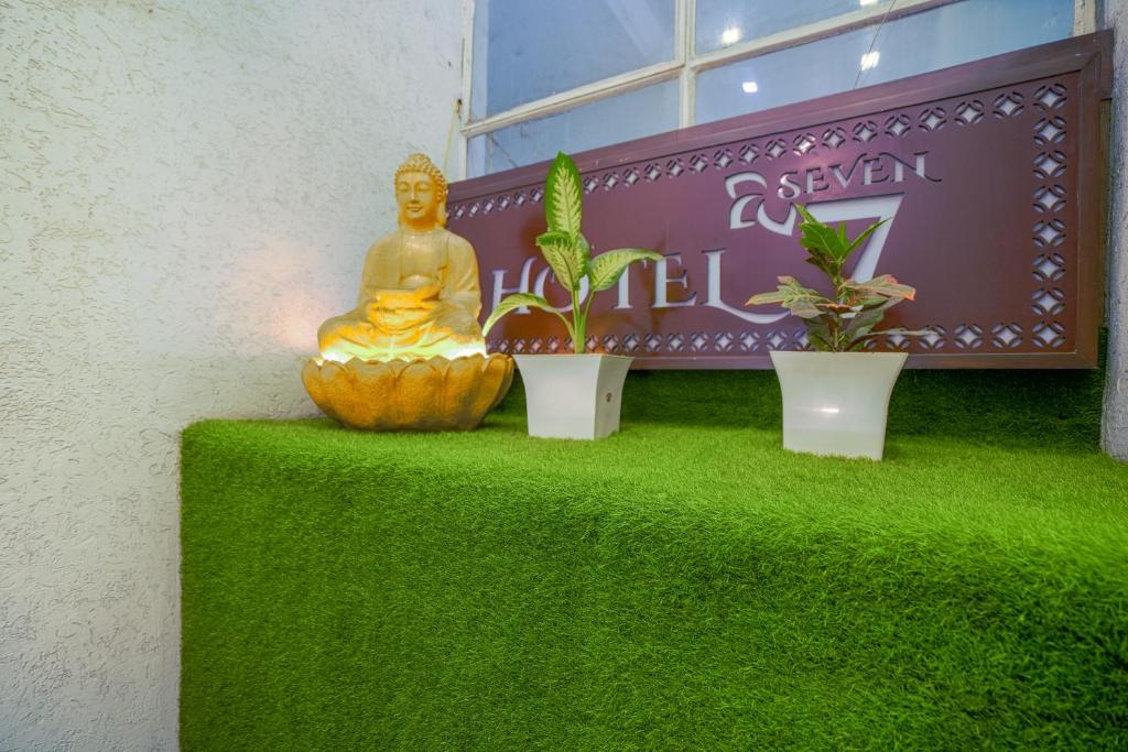a statue of a buddha sitting on a green table at Hotel Seven- Center of City Chandigarh in Chandīgarh
