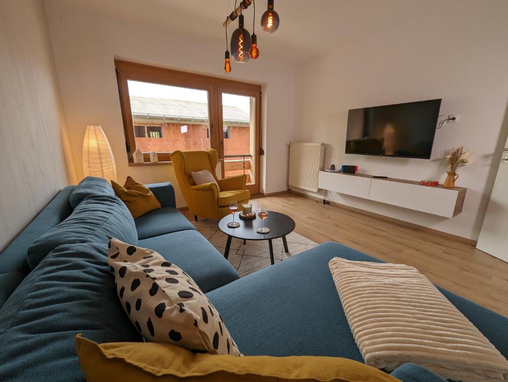 a living room with a blue couch and a tv at Angerpartments-Sonnige große Wohnung mit Balkon und kostenlosen Parkplatz in Döbriach