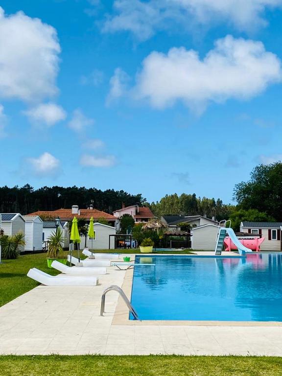 a large swimming pool with a slide in a yard at Casa Feliz in Burinhosa