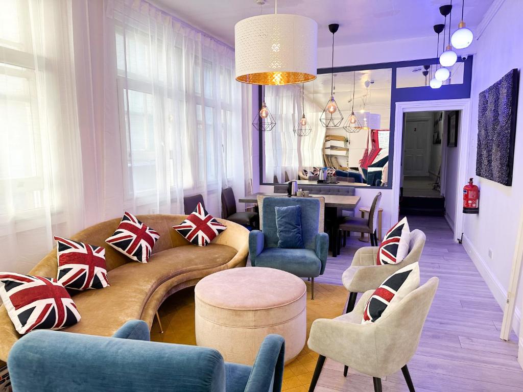 a living room with a couch and chairs and a table at Pink Door Guesthouse in London