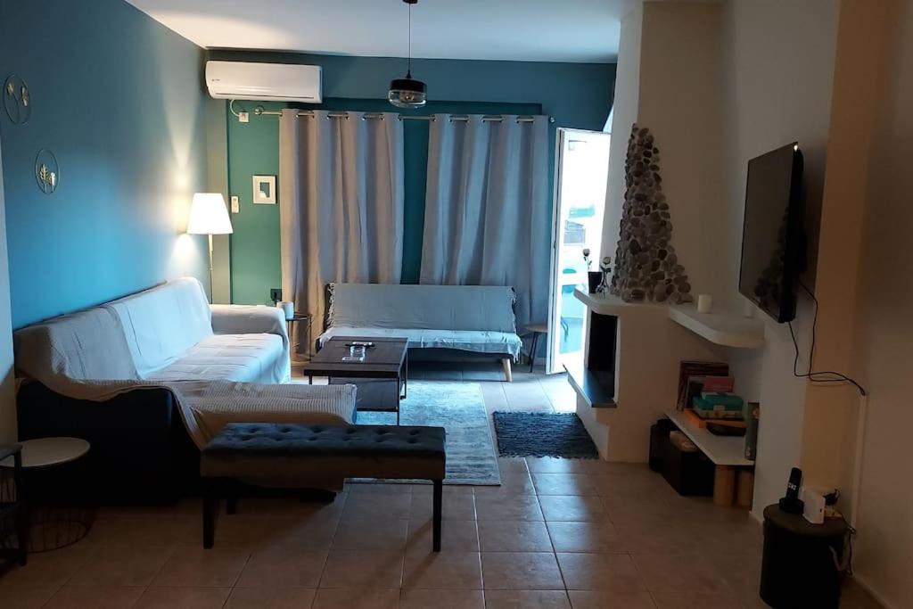 salon z kanapą i telewizorem w obiekcie Aegina luxury apartments w mieście Egina