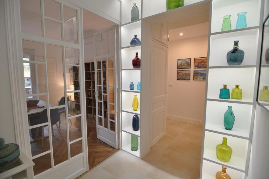 une pièce avec des vases en verre sur le mur dans l'établissement Palais Albert -2-Bedroom Apartment -Ponteil Beach -StayInAntibes, à Antibes