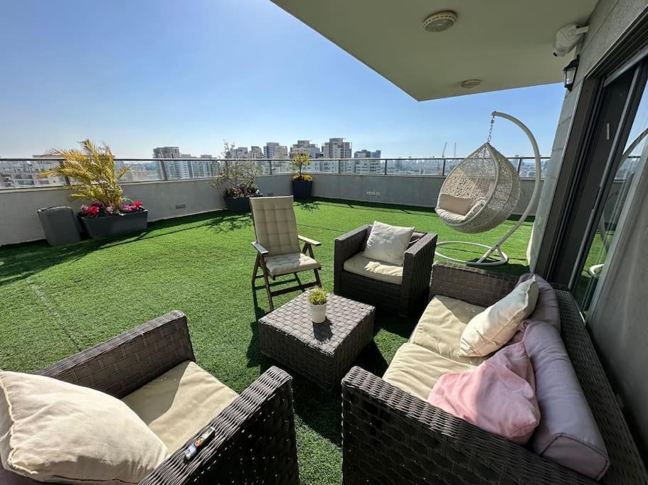 a patio with chairs and couches on a balcony at Penthouse, 23rd Floor 300sqm Near TLV in Petaẖ Tiqwa