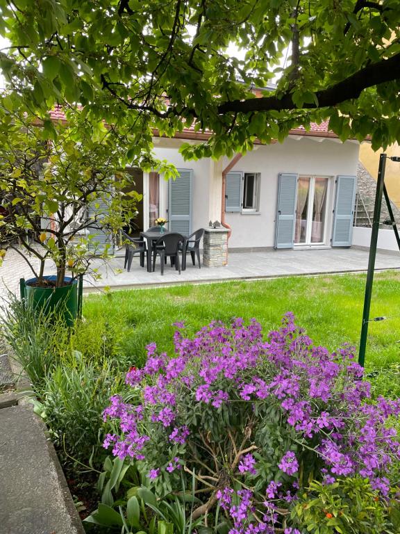 a garden with purple flowers in front of a house at Casa Tortora in Gravedona