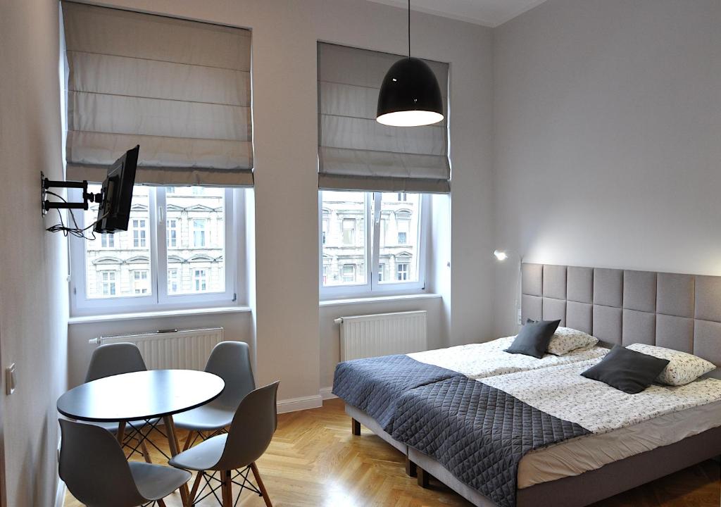 1 dormitorio con 1 cama, mesa y sillas en Wroclaw City Apartments, en Wroclaw