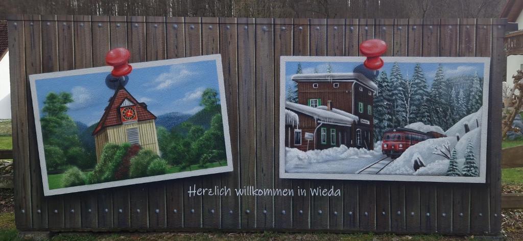 two posters on a fence with a picture of a train station at Ferienwohnung Am Berggipfel in Wieda