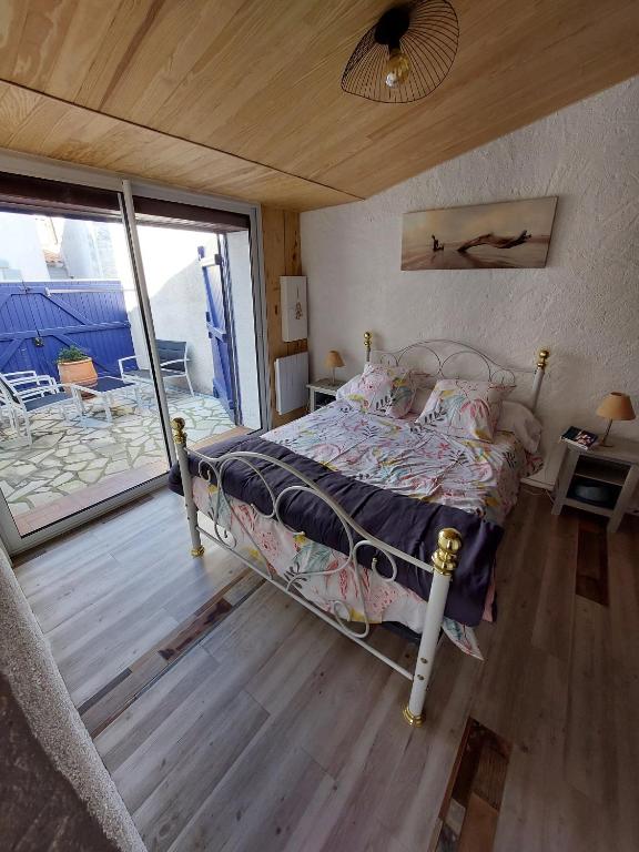 une chambre avec un lit et un balcon dans l'établissement Maison typique oléronaise, au Château-dʼOléron