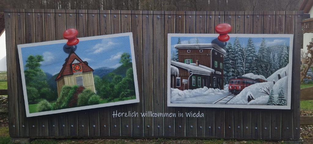 two posters on a fence with a picture of a train station at Ferienwohnung Am Berg in Wieda