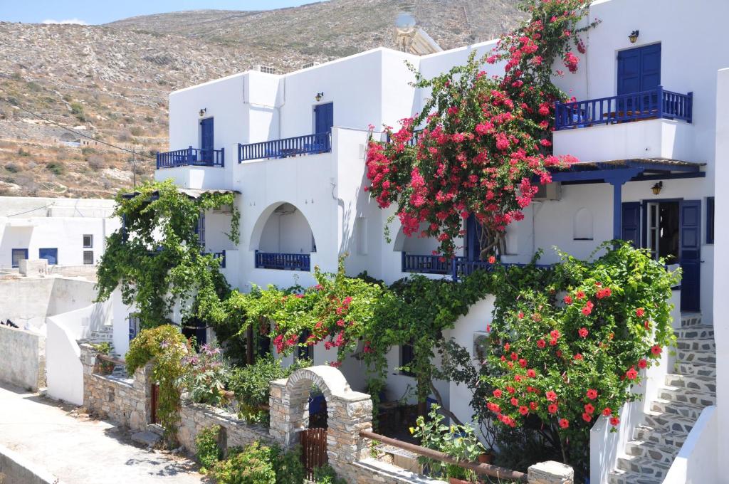 un bâtiment avec des fleurs devant lui dans l'établissement Nostos Studios, à Aegiali