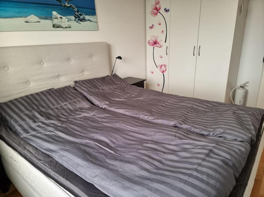 een bed met een paarse deken erop in een slaapkamer bij Trevlig lägenhet nära Strömstad centrum in Strömstad
