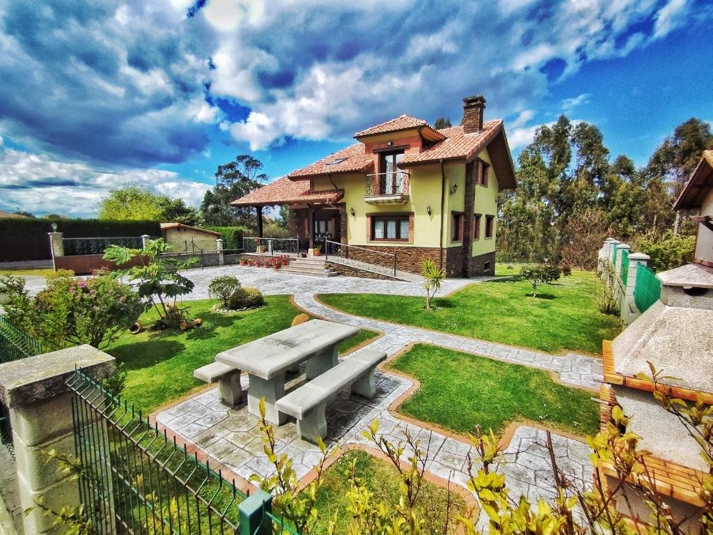 ein Haus mit einem Picknicktisch im Hof in der Unterkunft La Aguilerina Apartamentos Rurales in Oviñana