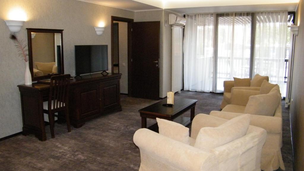 a living room with white furniture and a television at Apartament 2711 , proprietate privata in Aparthotel Alpin in Poiana Brasov