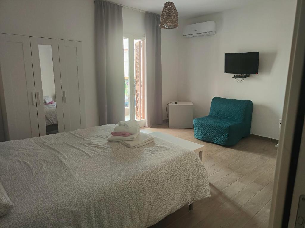 a bedroom with a bed and a blue chair at B&B Anninnía in Castelsardo