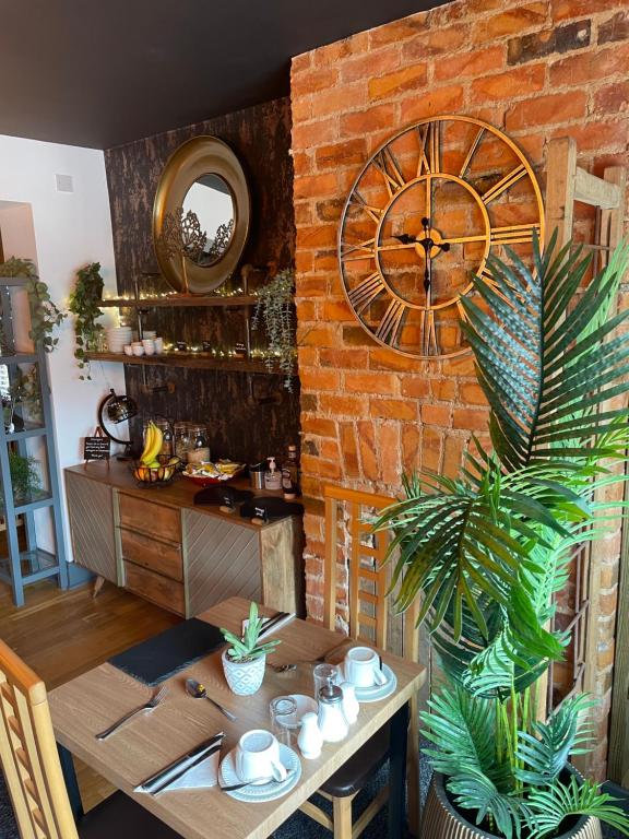 a dining room with a large clock on a brick wall at Park View in Scarborough