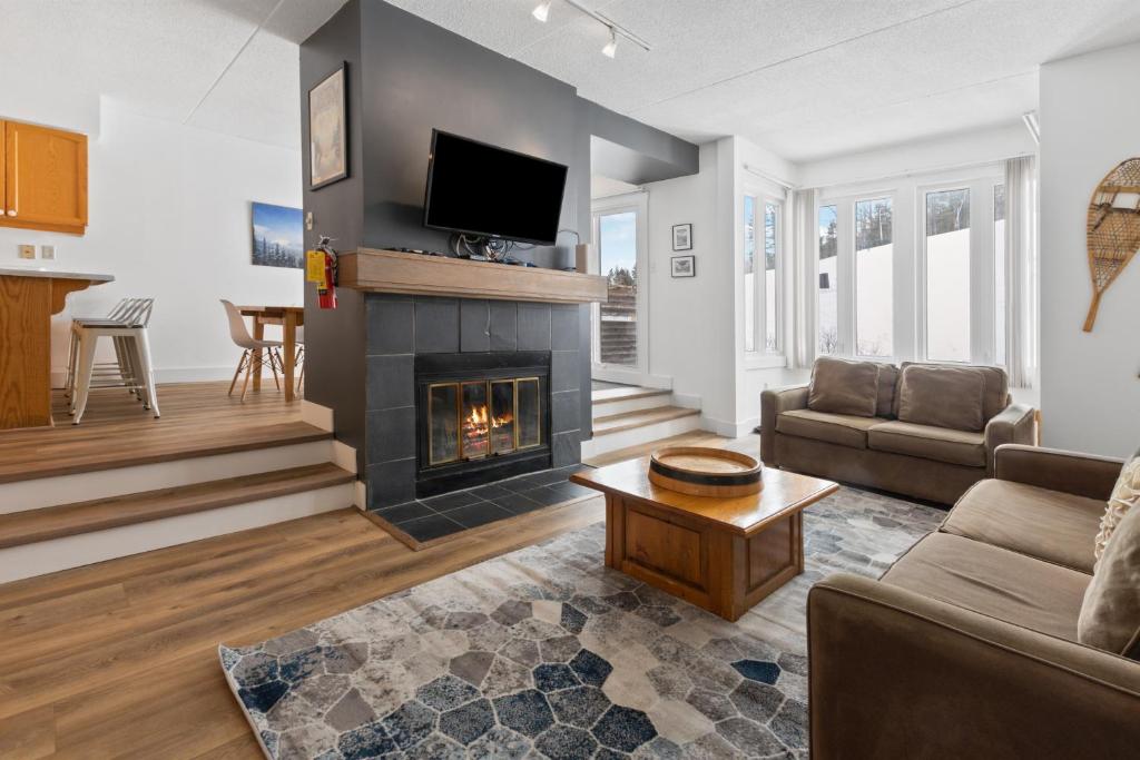 ein Wohnzimmer mit einem Kamin und einem TV in der Unterkunft Blue Mountain Ski In Ski Out Resort Condo 2 Level in Blue Mountains