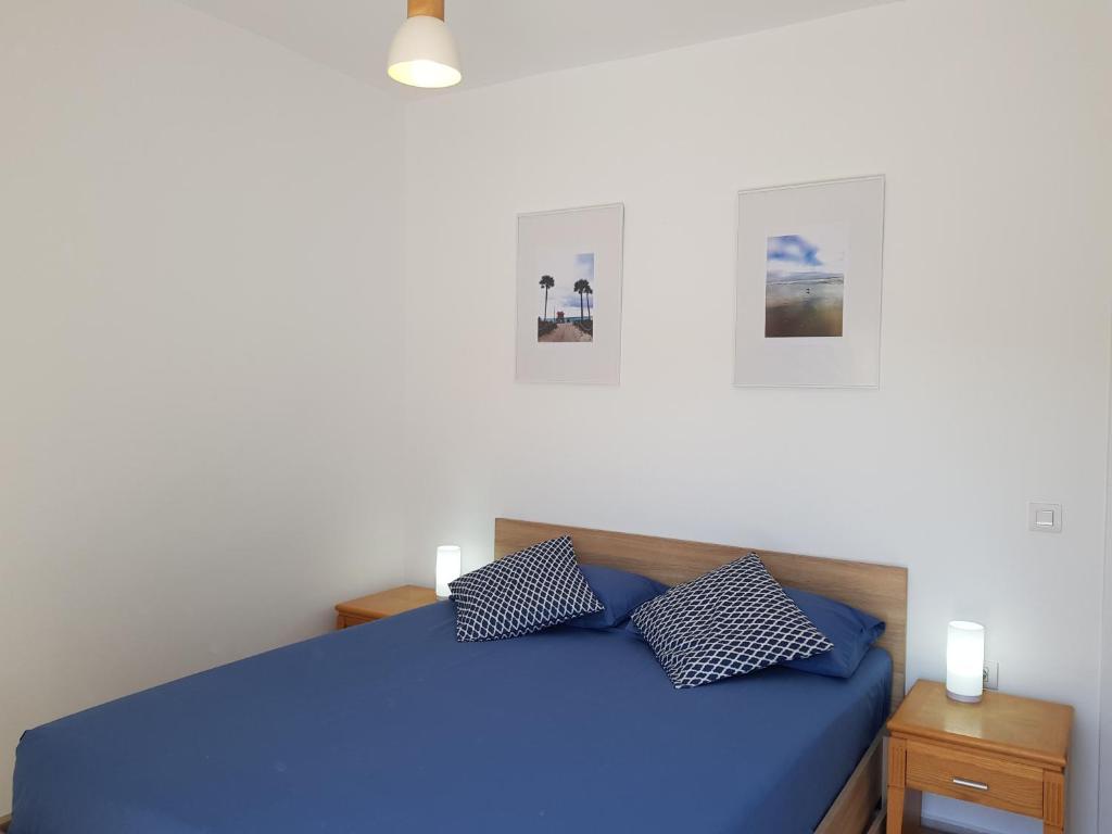 a bedroom with a blue bed with two pillows at Sea Breeze Apartment in Ixia