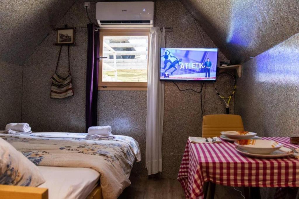 Cette chambre comprend 2 lits et une télévision murale. dans l'établissement Kućice Paradiso, à Bratunac
