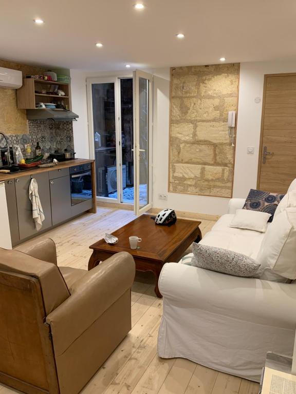 un salon avec un canapé et une table dans l'établissement appartement cosy avec climatisation et patio centre historique de Bordeaux, à Bordeaux