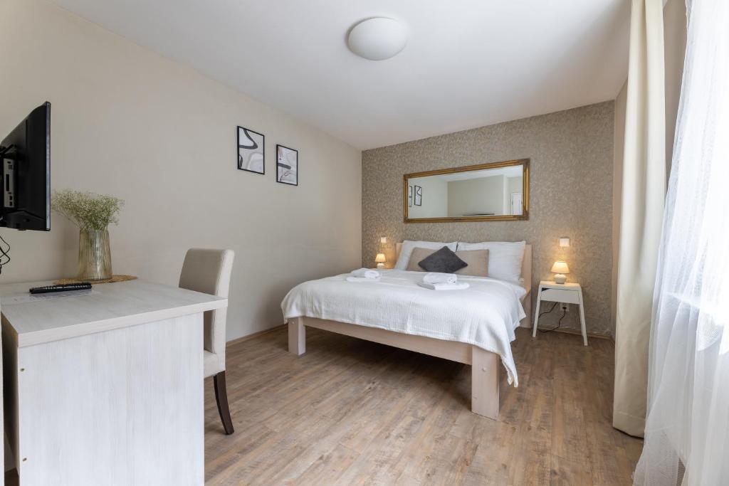 a bedroom with a white bed and a mirror at Apartmány U Pavla in Český Krumlov