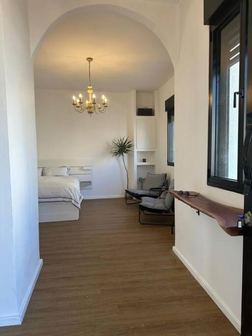 a room with a bedroom and a bed and a chandelier at Central Studio with a Garden in Tel Aviv