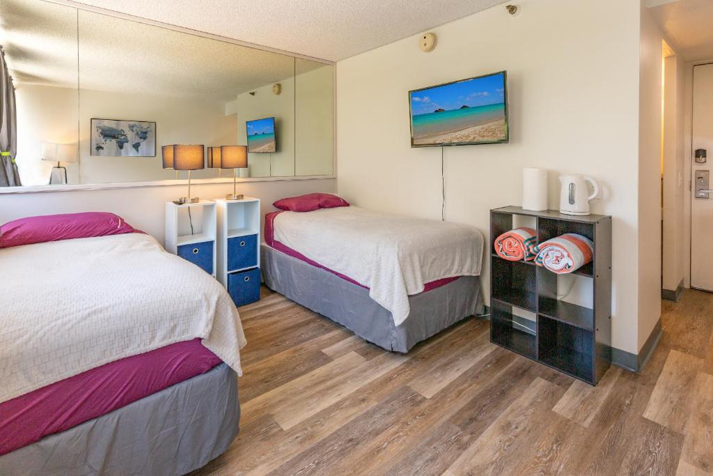 Habitación de hotel con 2 camas y espejo en soulfactory Hawaii, en Honolulu