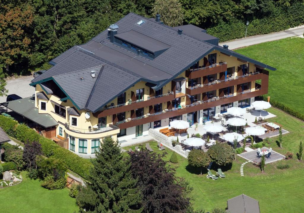 an aerial view of a hotel with tables and umbrellas at Hotel Aberseehof in Sankt Gilgen