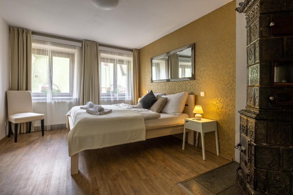 a bedroom with a large bed and two windows at Apartmány U Pavla in Český Krumlov