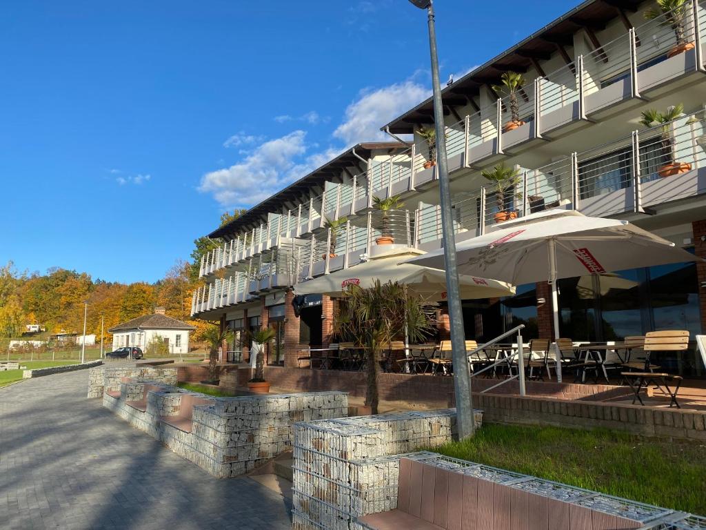 a building with tables and umbrellas in front of it at Pensjonat Długie Nowicki Rooms & Apartments in Długie