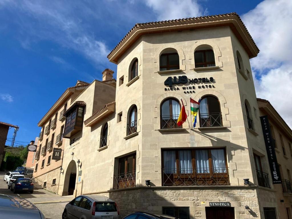 ein Gebäude mit zwei Flaggen auf der Seite in der Unterkunft 4US RIOJA WINE HOTEL in Cenicero