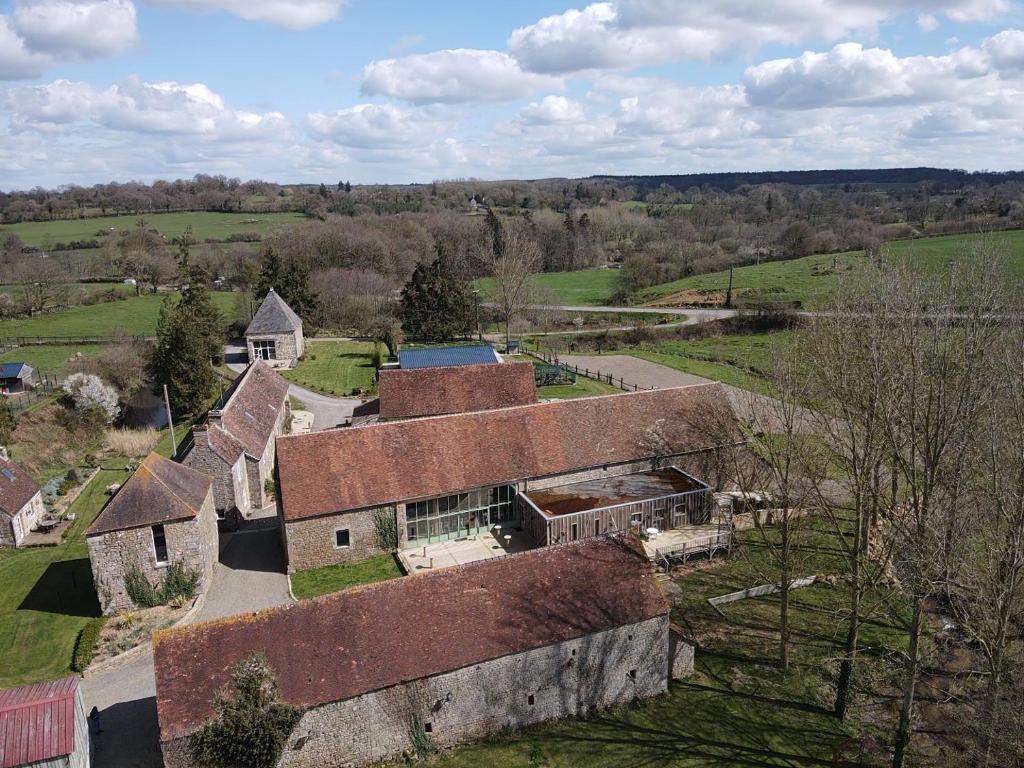een luchtzicht op een oud huis in een veld bij Domaine Des Tours Vauquelin in La Fresnaye-au-Sauvage