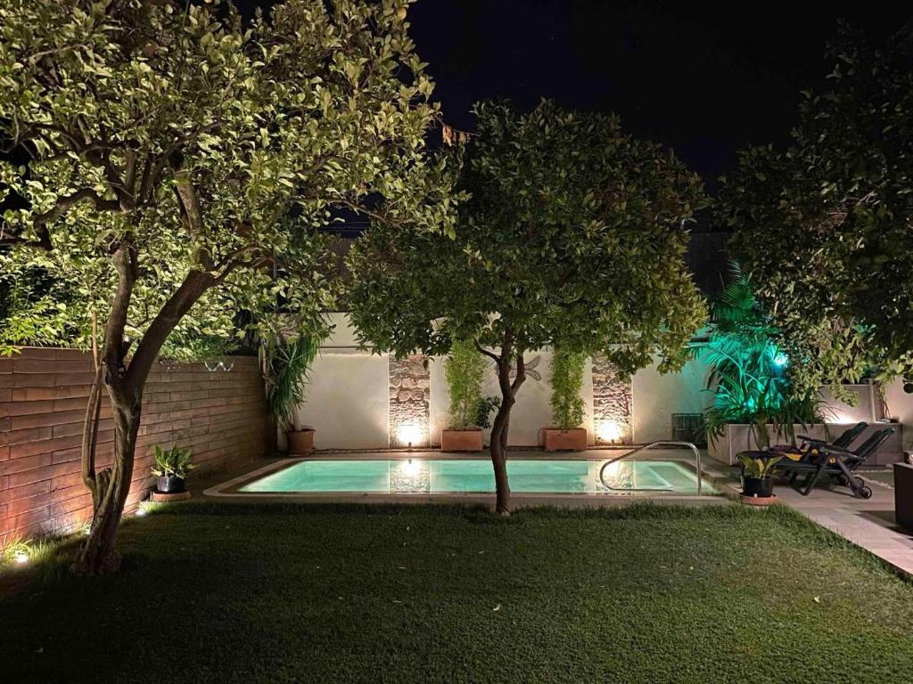 una piscina por la noche con árboles y luces en Apartamento Bizcocheros con piscina y jardín privado, en Jerez de la Frontera