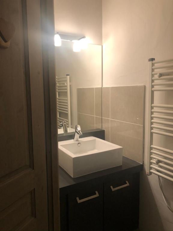 łazienka z białą umywalką i lustrem w obiekcie Ma tanière aux 7 Laux w mieście Les Adrets