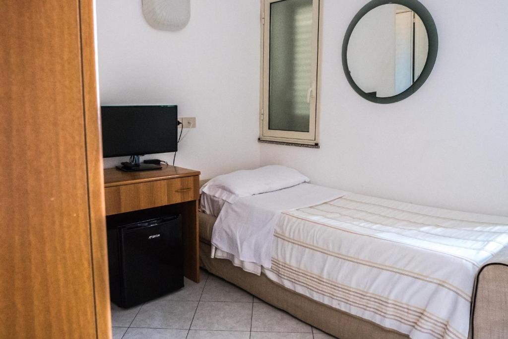 a small bedroom with a bed and a television at Hotel Villino Gallodoro in Taormina