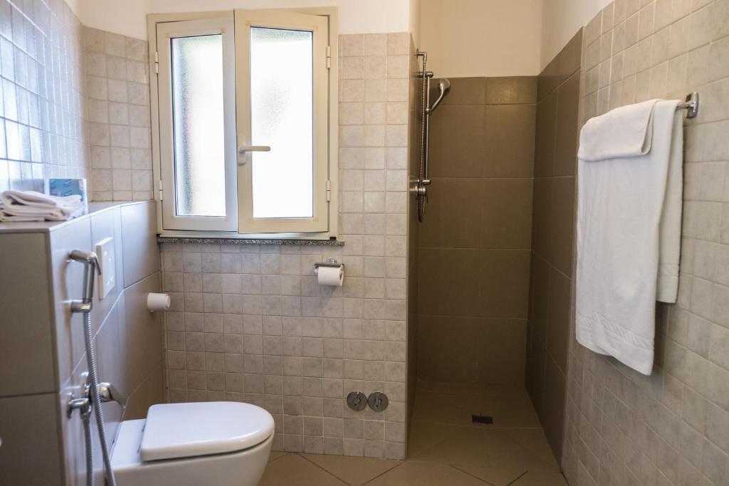 a bathroom with a shower and a toilet and a window at Hotel Villino Gallodoro in Taormina