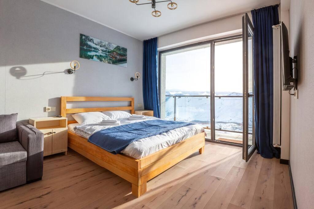 1 dormitorio con cama y ventana grande en Room310 en Gudauri