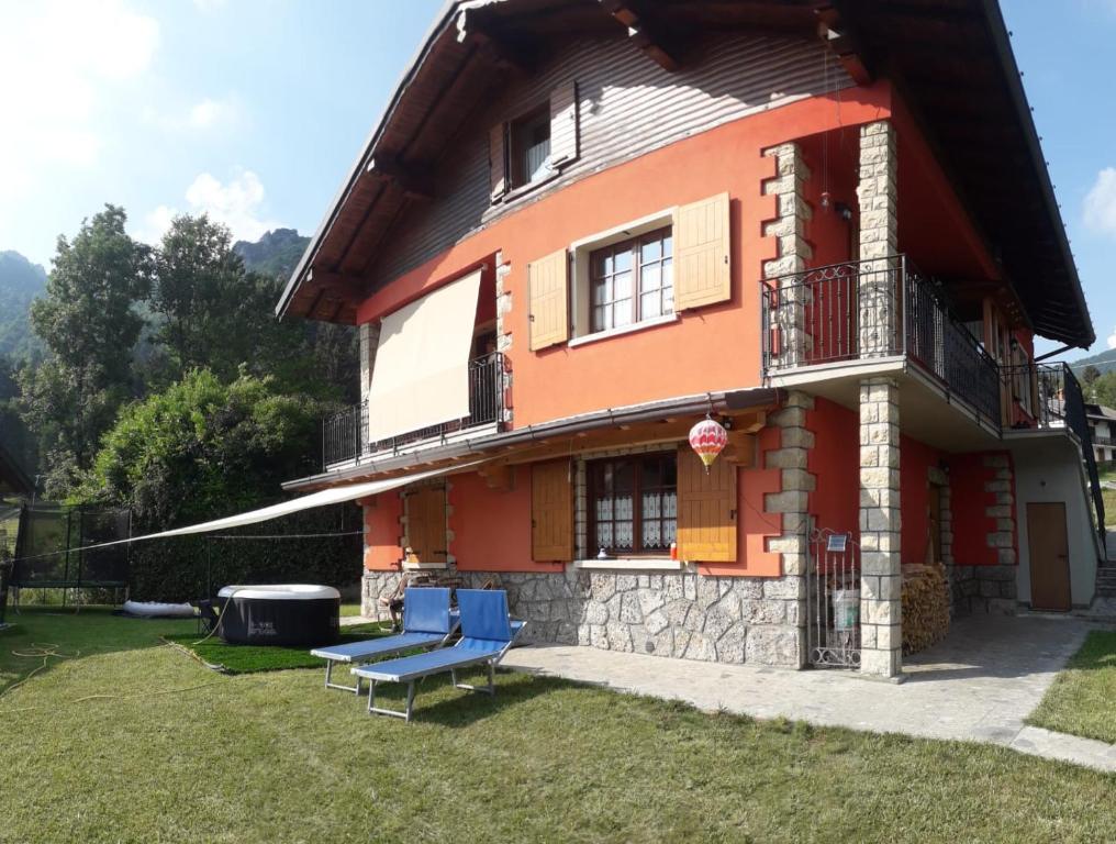 a house with a blue bench in front of it at La Casa Rossa - Presolana in Castione della Presolana